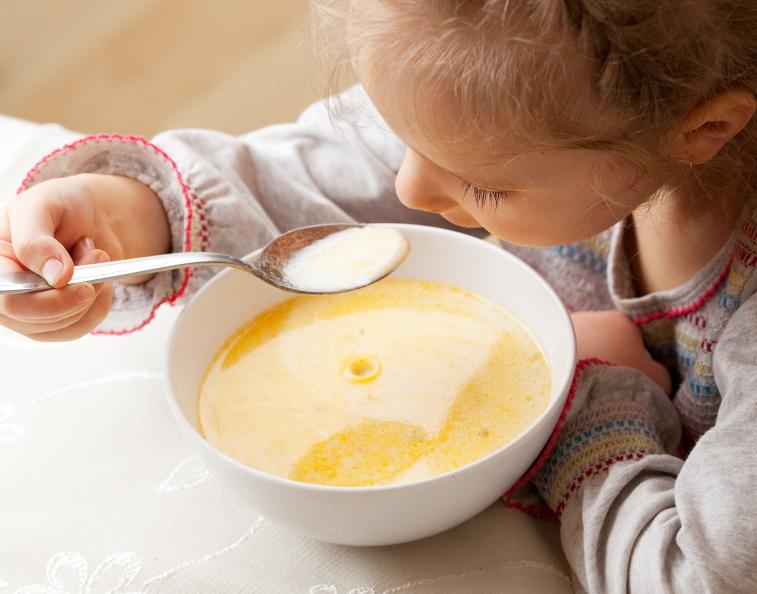 Bild på ett barn som äter soppa.