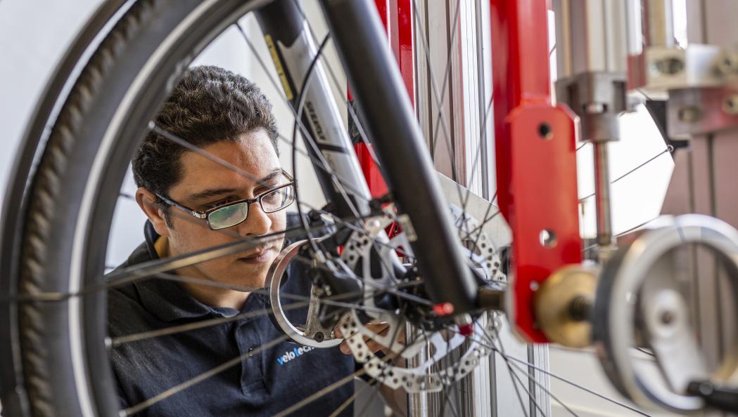 Redouane Bouassaba, testtekniker på velotech.de, fixerar cykelns hjul i testriggen eRig. Foto: Stefan Ernst. 